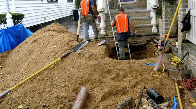 Contractors performing foundation protection and exterior drainage excavation near residential home steps in Oakland, CA